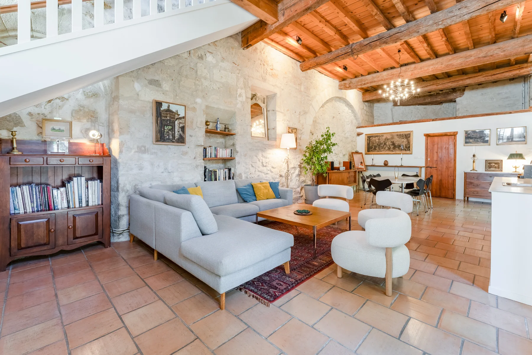 Living room at Le Clos: bookcase, armchairs and exposed beams